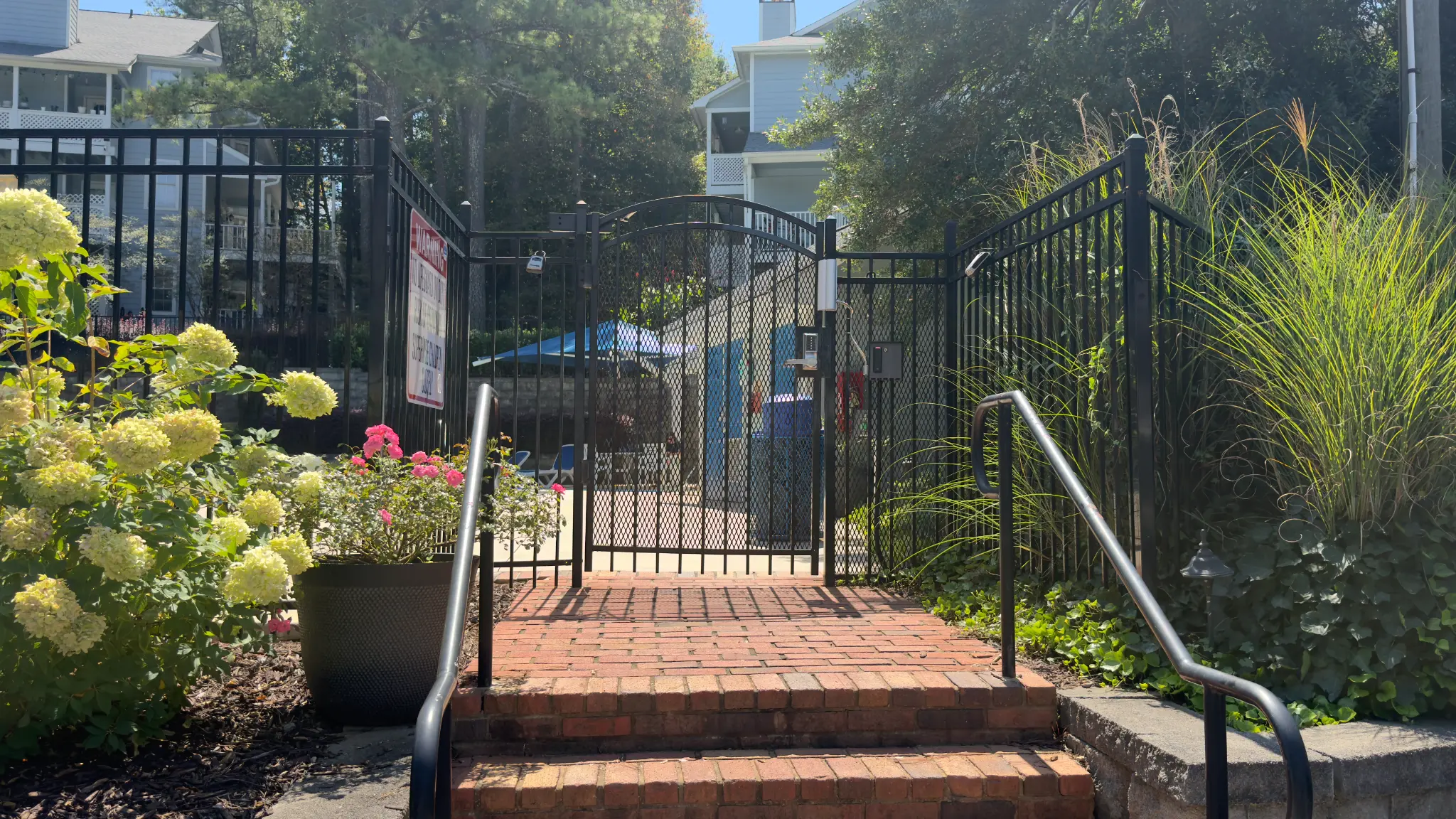 Landscaped approach to The Willows HOA pool gate with access control in Marietta, Georgia